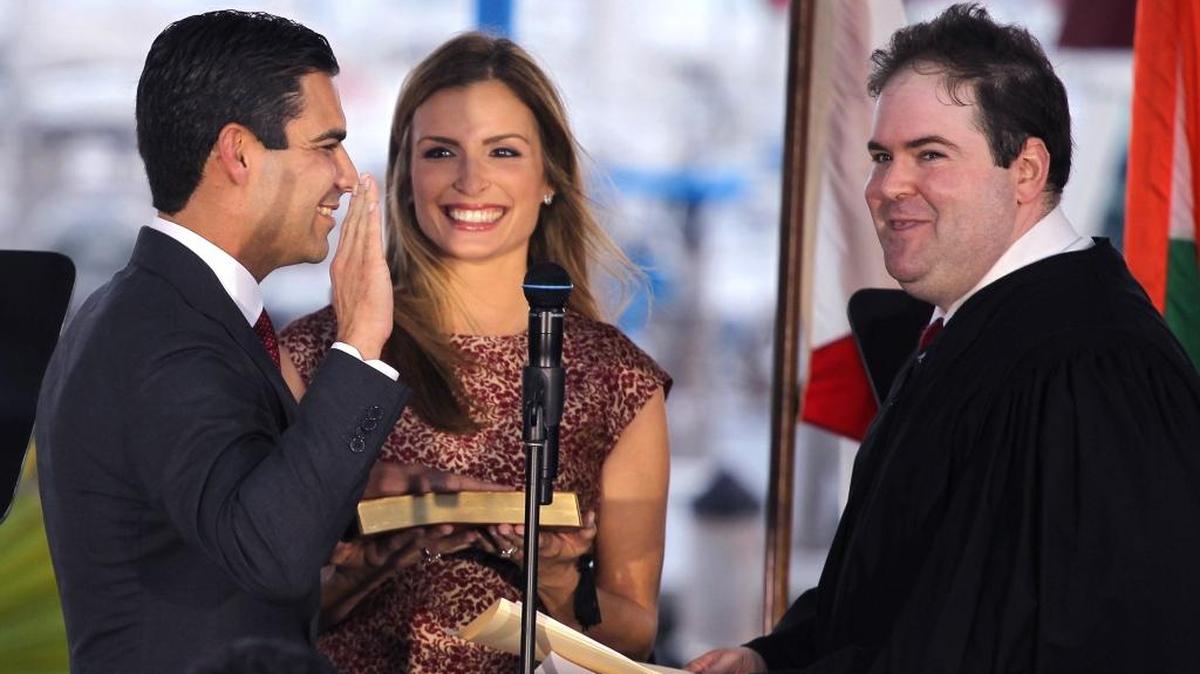 Francis Suarez is sworn in as mayor of Miami by Judge Robert Luck, right, while his wife, Gloria, holds the Bible.