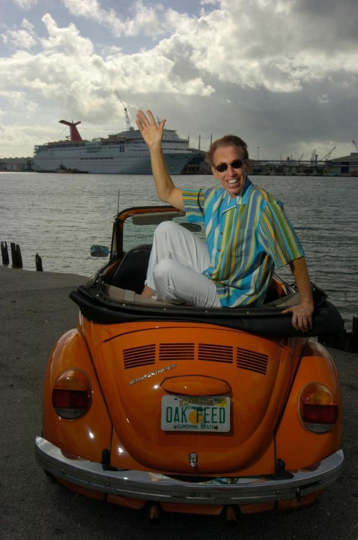Sandy Pukel sitting on the VW Beetle he has owned since 1973. Pukel, formerly of the Oak Feed store, parked near the MacArthur Causeway for the photo.