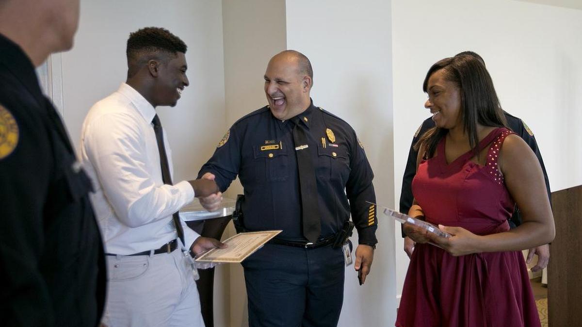 
Miami Police Commander Manny Morales congratulates Iandrick Brown, 17, left, and Karen Smith, 18, two exemplary participants in the Inaugural Youth Empowerment Program, at a graduation ceremony Wednesday at the Sonesta Bayfront Hotel Coconut Grove.
