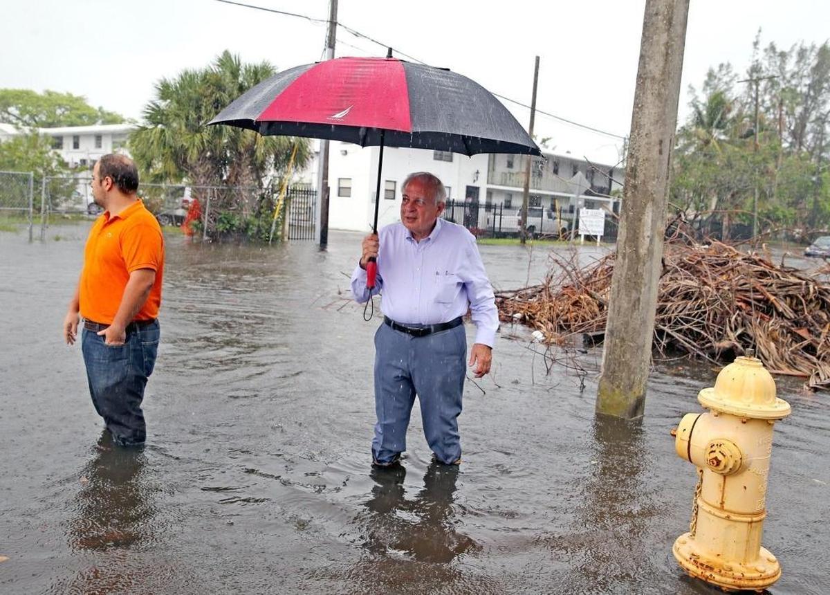 Miami Mayor Tomas Regalado and his son Jose Regalado walk through the flooded streets in Shorecrest after a combination of rain and king tide flooded the area on Oct. 5, 2017.