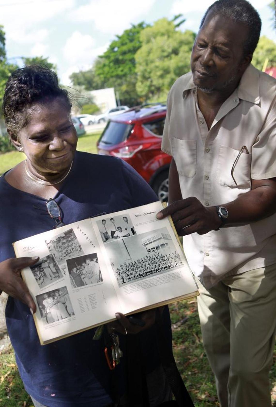 Linda Williams, left, a lifelong resident of the West Grove in Miami's Coconut Grove; and Williams Armbrister, whose family settled in the West Grove three generations ago, show a 1961 Hornet yearbook with a photo of the graduating class of Carver Senior High School gathered in front of Old Smokey, the incinerator that dominated the landscape until the early 1970s, when it was demolished. Armbrister is a client of the law firm that has filed a class-action lawsuit against the city.