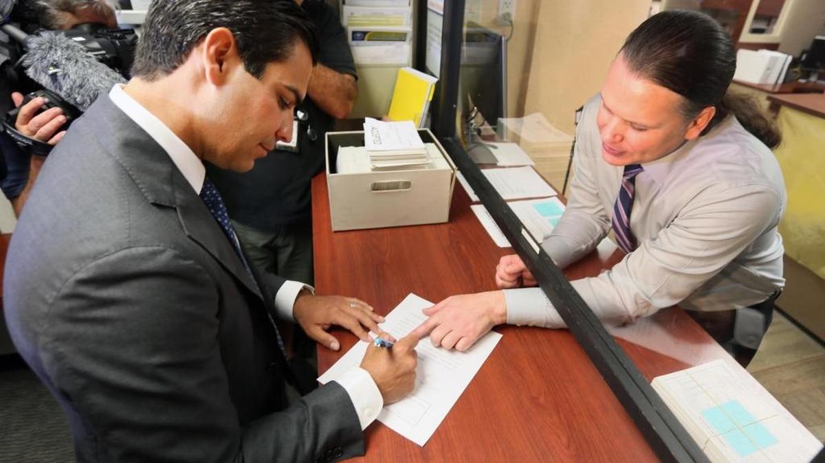Miami City Commissioner Francis Suarez signs paperwork in front of City Clerk Todd Hannon after submitting petition signatures on Thursday, Aug. 10, 2017, to qualify for the November ballot as a candidate for Miami mayor.