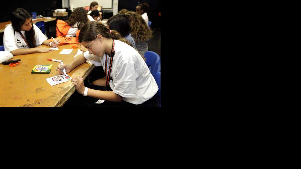 
Nidia Bejar, (center with white shirt) makes a card on bullying in a digital citizenship class about cyberbullying at the Patricia and Phillip Frost Museum of Science. She was among teenagers, ages 11-16, who were invited to a free Geek Squad Academy session on Saturday to learn how to recognize and stop cyberbullying. 
