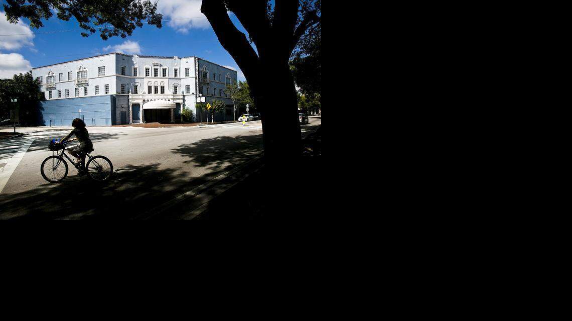 
A woman rides her bike past the vacant Coconut Grove Playhouse. Some significant development plans and property ownership changes are currently taking place in Coconut Grove.
