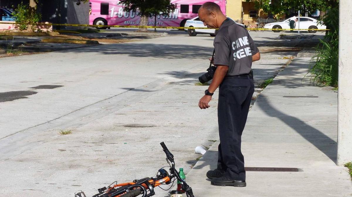 
A Miami crime scene investigator analyzes the area of a shooting in Coconut Grove on Wednesday.
