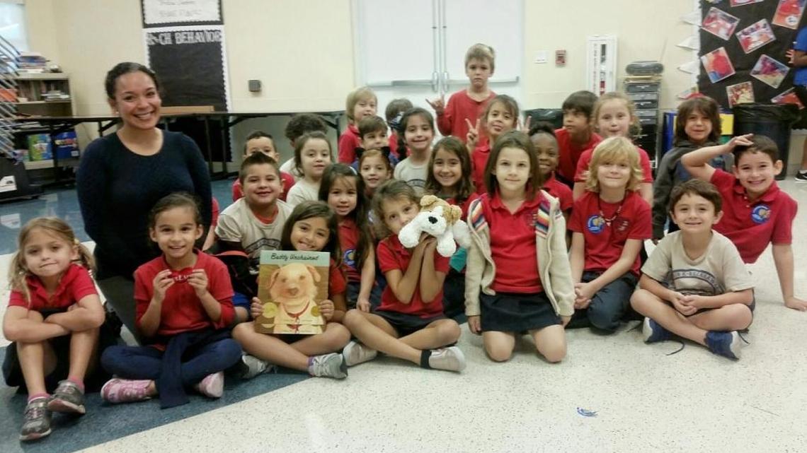Magaly Madrid is the first Miami-Dade County teacher to win PETA’s TeachKind Teacher of the Year award. Pictured, Madrid and her first-grade students complete the book “Buddy Unchained,” based on a true story about an abused dog who was rescued by a animal shelter worker and adopted by a loving and caring family.