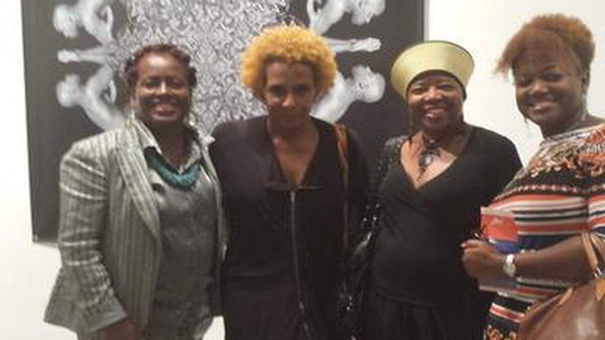 
Art of Black Event: Art of Transformation Kick off Event in Opa Locka, In Plain Sight Opening Reception. L-R: Graylyn Swilley- Woods, interim VP GMCVB Multicultural Department; Renee Cox, Artist, Carole Ann Taylor, GMCVB Board Heritage Committee Chair; and Petra Brennan, GMCVB Multicultural Department standing in front of artwork by Renee Cox. 
