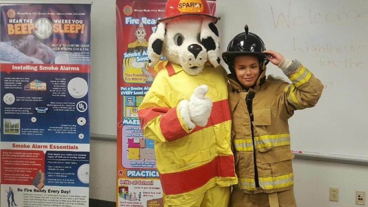 Miami-Dade Fire Rescue’s mascot Sparky the Fire Dog makes a new friend, camper Christian Mulet, at a special fire safety demonstration for students in the Miami Lighthouse for the Blind and Visually Impaired summer program.