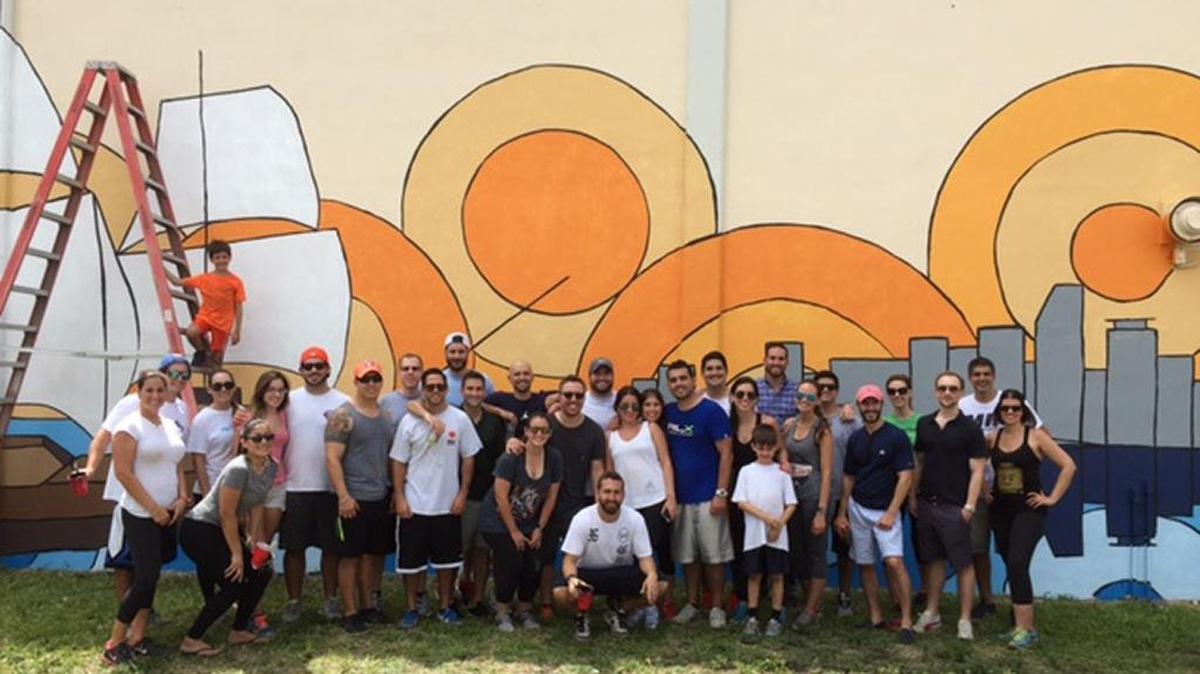 Volunteers with the Ponce Society of Young Professionals join artist Michael Halley to create this mural at Ponce De Leon Middle School.