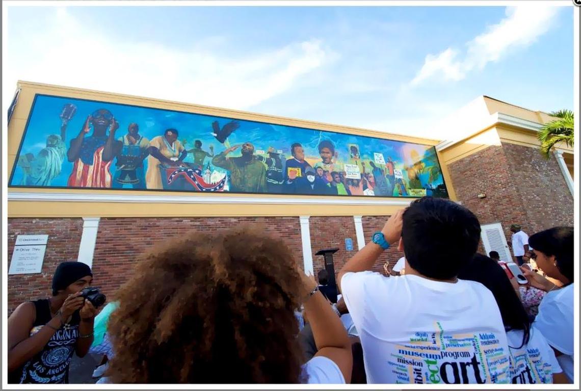 ‘Thunder & Enlightening’: Students participate in the 2015 Liberty City Renaissance project at One United Bank, 3275 NW 79th St., taking pictures of the mural they contributed to with artist Addonis Parker.