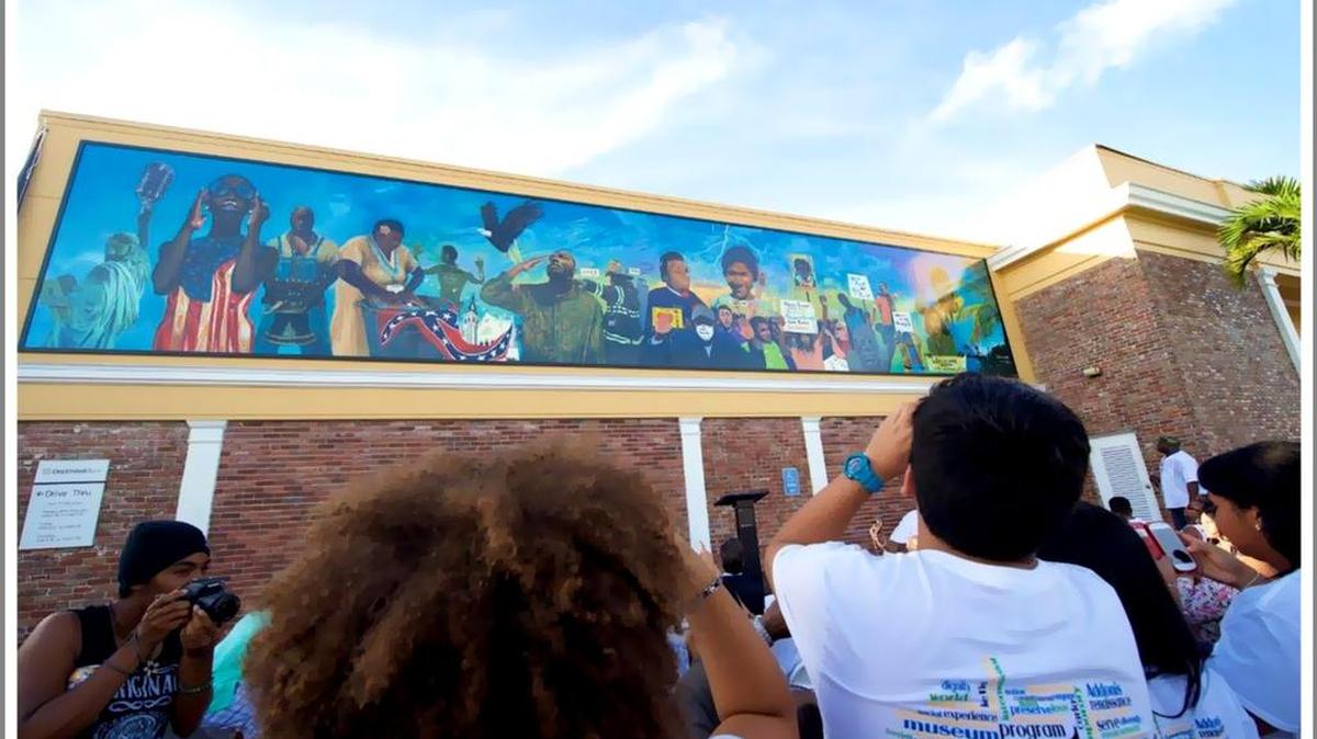 ‘Thunder & Enlightening’: Students participate in the 2015 Liberty City Renaissance project at One United Bank, 3275 NW 79th St., taking pictures of the mural they contributed to with artist Addonis Parker.