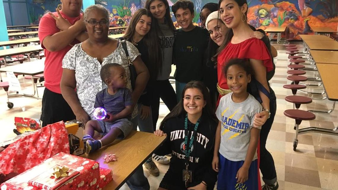Student volunteers Rachel Rodriguez and Aileen Roa, dressed as Disney characters, at the annual Adopt A Family event held at Coral Reef Senior High with their adopted family, the Coffies.