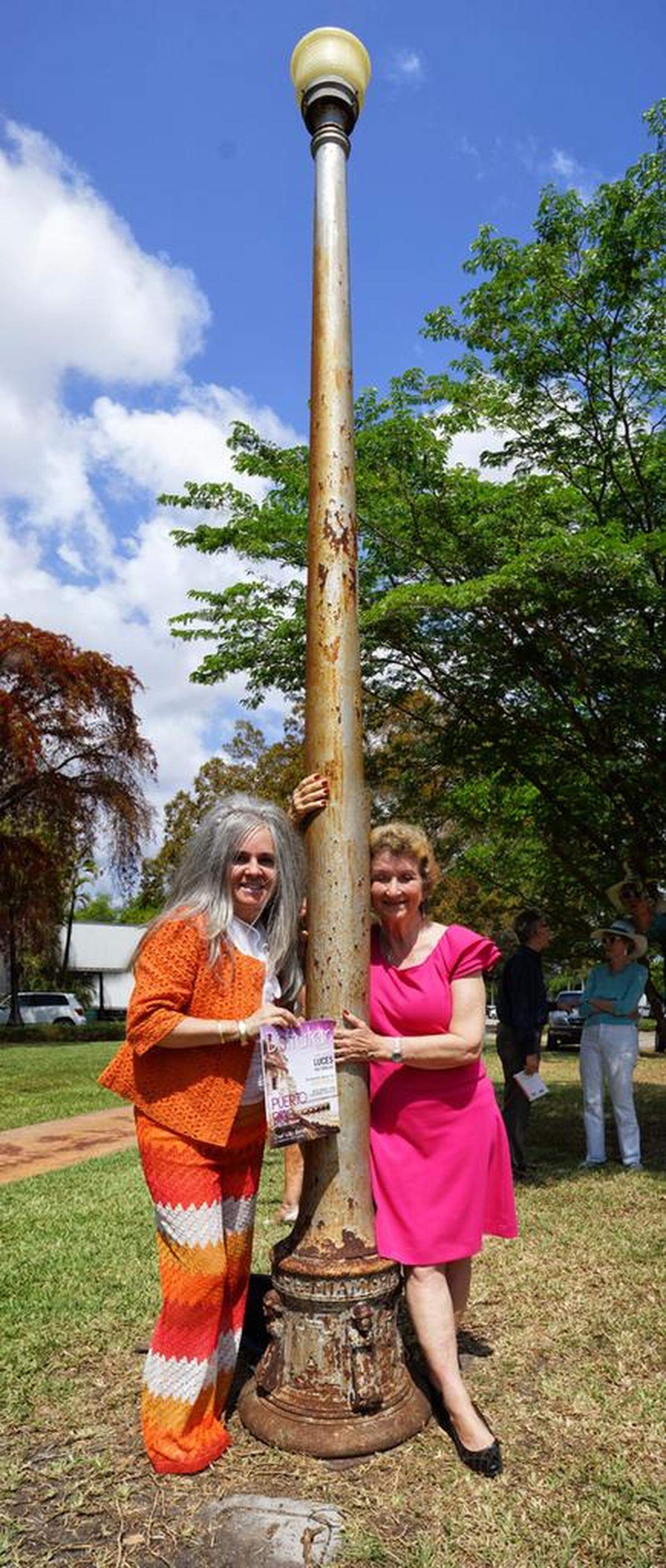 The Historical Preservation Association of Coral Gables is on a mission to save the last few of the original 1926 city streetlights. From left, HPACG president Karelia Martinez Carbonell, and former HPACG board member Connie Crowther hug one of the historic lamps commissioned by Coral Gables Founder George Merrick. Of the original 500, only 41 remain standing.