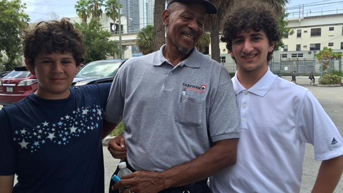 From left, Jon Tandy, Chapman Partnership employee Ben Johnson and Harrison Tandy celebrate another delivery of books for the homeless.