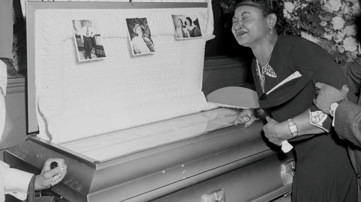 In this 1955 file photo, Mamie Mobley, mother of Emmett Till, pauses at her son's casket at a Chicago funeral home. The 14-year-old Chicagoan was killed in 1955 after reportedly whistling at a white woman during a visit to his uncle's house in Mississippi. Nearly 100,000 people visited his glass-topped casket during a four-day public viewing in Chicago. Images of his battered body helped spark the civil rights movement.