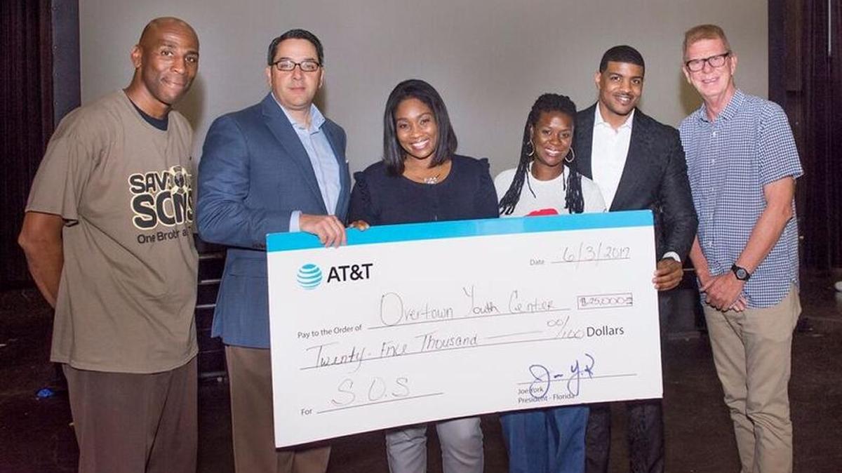 The seventh annual Save Our Sons Youth Summit, hosted by Alonzo Mourning’s Overtown Youth Center, inspired young men to excel through workshops and activities. AT&T representatives surprised the group with a check for $25,000 to support community programs. From left, Lyle Grandison, president of Respect for Life Educational Services; Stephen Marino, Overtown Youth Center board chairman; Cristal Cole, AT&T Florida-External Affairs; Tina Brown, executive director OYC; Shawn Blanchard, keynote speaker; and Kevin Vericker, city of Miami mayor’s office.