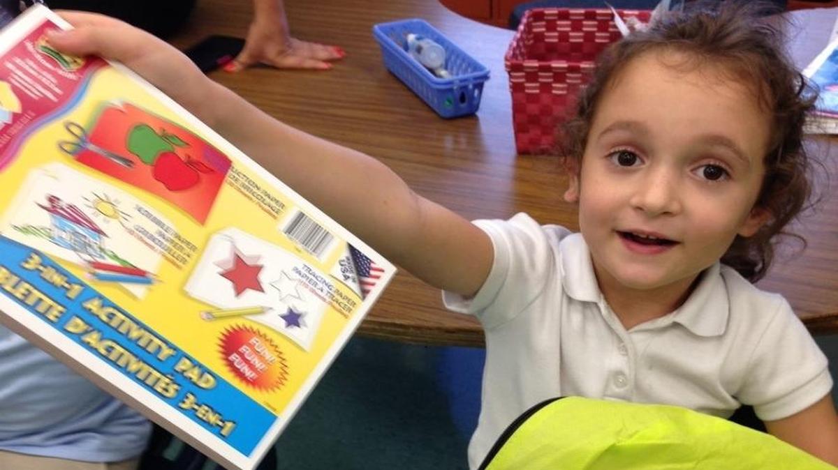 Samantha Joy Dillenbeck, at the Palm Springs Elementary School Program for students who are deaf or hard of hearing, was excited with each item she took out of her book bag donated by the South Florida Deaf Recreation Association.