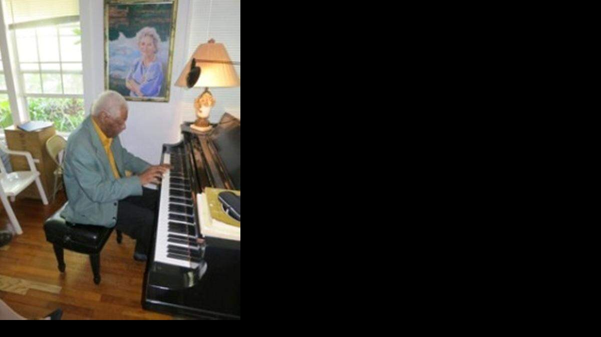 
Overtown resident James Ford plays the piano. Above him is a portrait of his teacher, mentor and friend, Ruth Greenfield. Greenfied’s husband, Arnold, painted the portrait in 1990.

