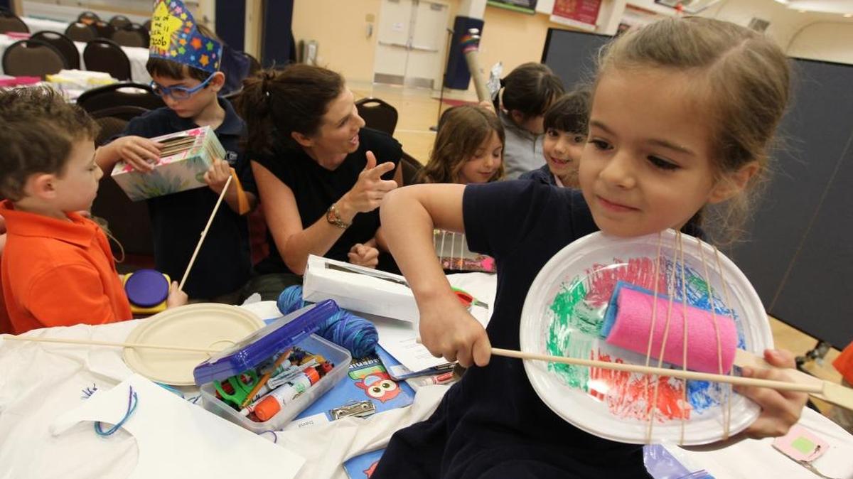 Daniela Baer, right, plays an instrument that she created in the classroom as teacher Jodi Barras talks with her students at Temple Beth Am Day School on on Wednesday, March 1, 2017 in Pinecrest. Temple Beth Am Day School has established a uniquely creative enrichment program that presents students with open-ended challenges that encourage learning through engagement in the creative process.