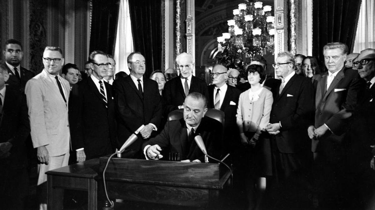 President Lyndon B. Johnson signs the Voting Rights Act of 1965 in a ceremony in the President's Room near the Senate chambers in Washington, D.C., on Aug. 6, 1965. Surrounding the president from left directly above his right hand: Vice President Hubert Humphrey; House Speaker John McCormack; Rep. Emanuel Celler, D-N.Y.; first daughter Luci Johnson; and Sen. Everett Dirkson, R-Ill. Behind Humphrey is House Majority Leader Carl Albert of Oklahoma; and behind Celler is Sen. Carl Hayden, D-Ariz.