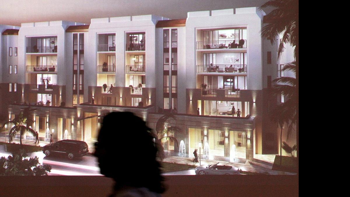 
A person walks past a rendering of Biltmore Parc, the first preconstruction boutique condominium project announced in Coral Gables in the last six years on Tuesday, April 28, 2015.
