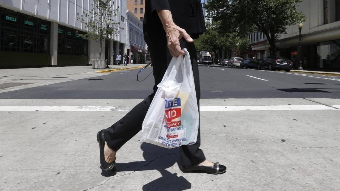 A woman walks with a plastic bag in Sacramento, Calif., on Wednesday, May 14, 2014.