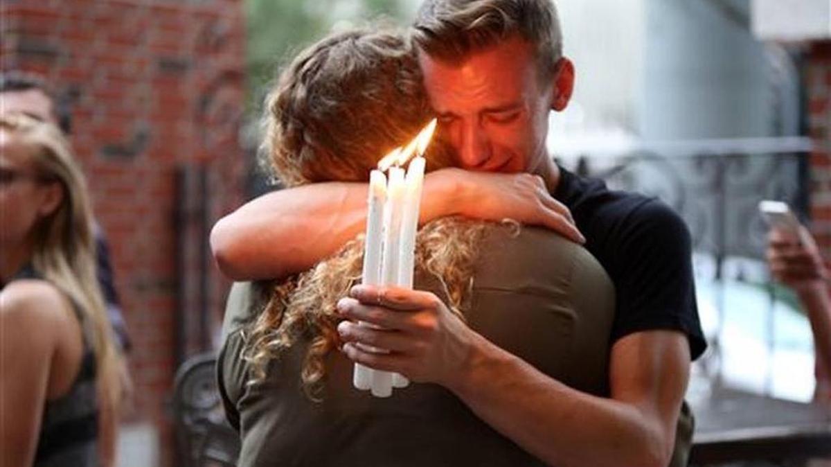 Brett Morian, from Daytona Beach, hugs an attendee during the candlelight vigil for the Pulse shooting victims in Orlando on June 12, 2016.
