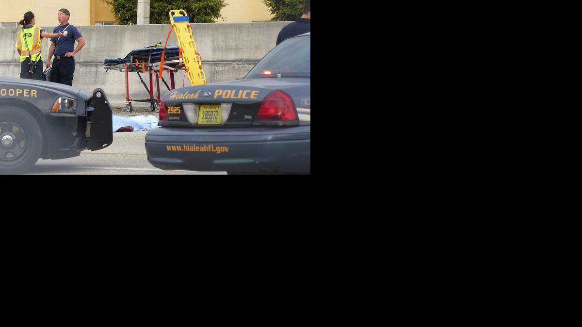 
HOLIDAY TRAGEDY : A woman’s body lies on the Palmetto Expressway near Northwest 103rd Street in Hialeah.
