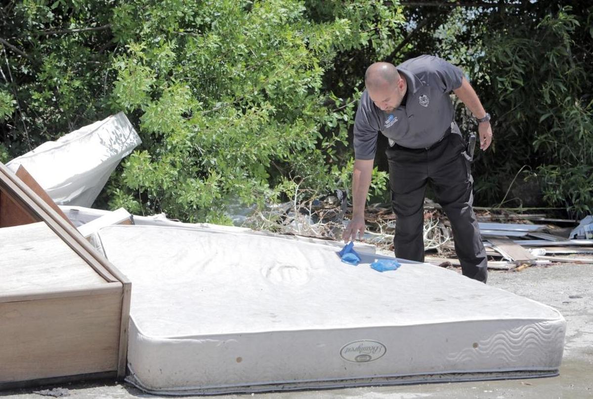Waste Enforcement Officer Santiago Callejas leaves his latex gloves on top of the latest pile of dumped refuse he has gone through. His small contribution to the trash pile is designed to warn future illegal dumpers that the county deploys people to sort through the rubble and try to track down culprits.