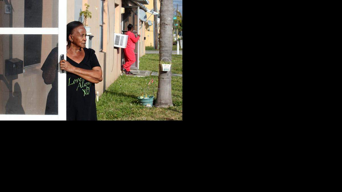 
Waltermae Martin looks out her front door in Liberty Square on Northwest 63 Street. Martin has lived in the project since 1973. Miami-Dade County has a $74 million dollar plan to move tenants of Liberty Square out of Miami's most notorious public-housing project, and into new digs in order to bulldoze and redevelop the complex.
