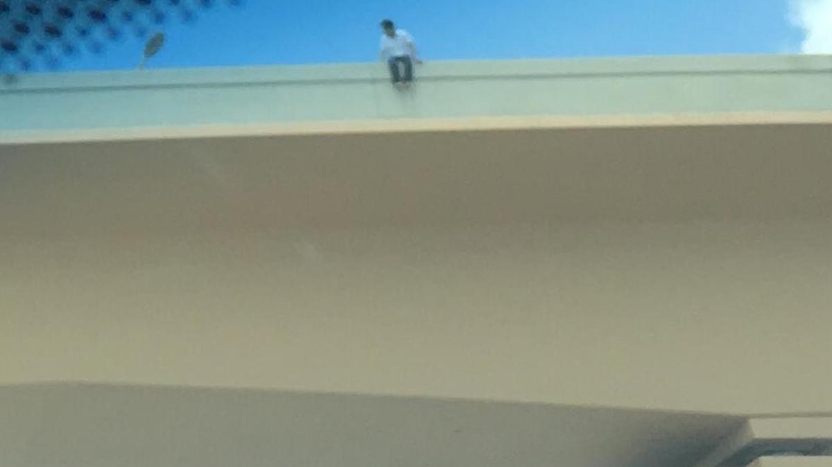 In this image sent in by a reader, a man sits on the ledge of the Dolphin Expressway overpass. Officials said negotiators were able to talk the man down.