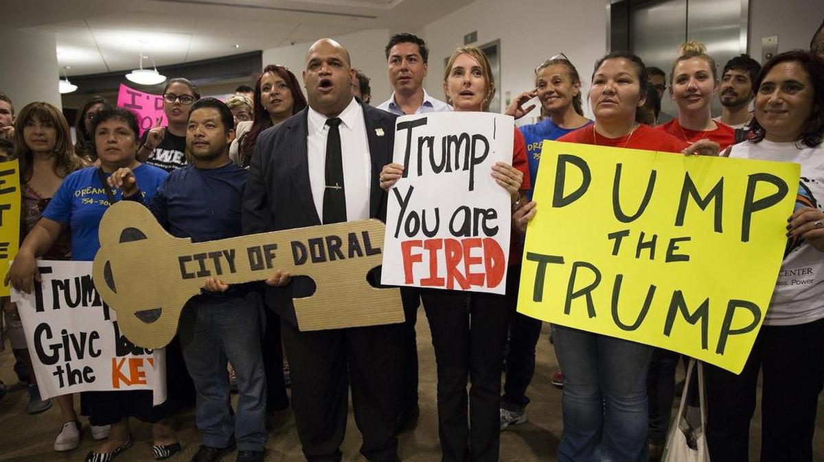 
Community members and activists hold up signs denouncing Donald Trump’s comments against Mexican immigrants to Doral City Council on Wednesday, Aug. 5, 2015.
