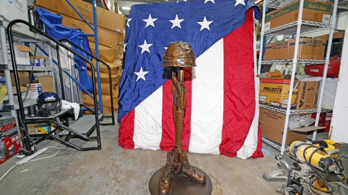 The future Miami-Dade Vietnam War Memorial, a bronze statue, as shown to the Miami Herald inside a Doral warehouse on March 30, 2016 with an improvised patriotic backdrop fashioned by a Doral parks worker. The city of Doral plans to affix the bronze statue to a concrete block and put it in Veterans Park by Memorial Day.
