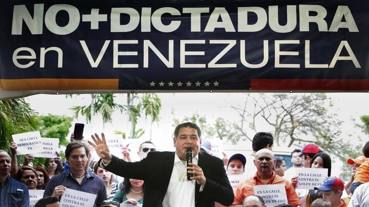 Luis Florido, center, speaks to a gathering of local Venezuelans protesting Wednesday’s Supreme Court ruling seizing power from the Venezuelan National Assembly. The crowd gathered at El Arepazo Original in Doral on March 31, 2017.