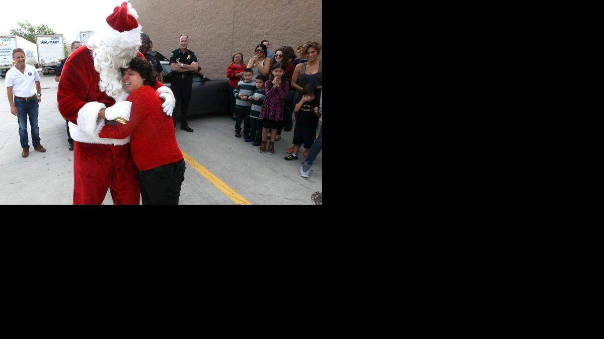 
Santa gets a big hug from mom Samantha on Saturday, Dec. 20, 2014, at Walmart in Doral. Walmart teamed up with the Doral Police Department to host the annual “Shop with a Cop.” More than 50 children from low income families received a Walmart gift cards and could choose gifts throughout the store alongside Doral police.
