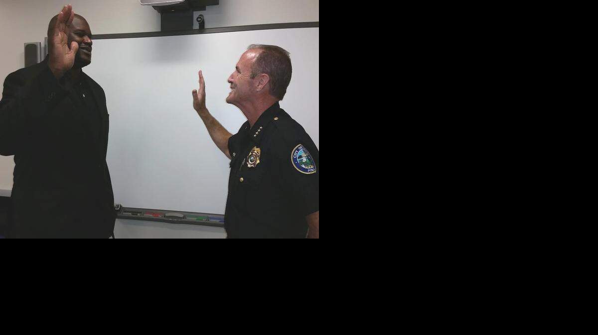 
Former Miami Heat star Shaquille O’Neal is sworn in as a reserve police officer by Doral Police Chief Donald De Lucca at the Doral police department Tuesday afternoon.
