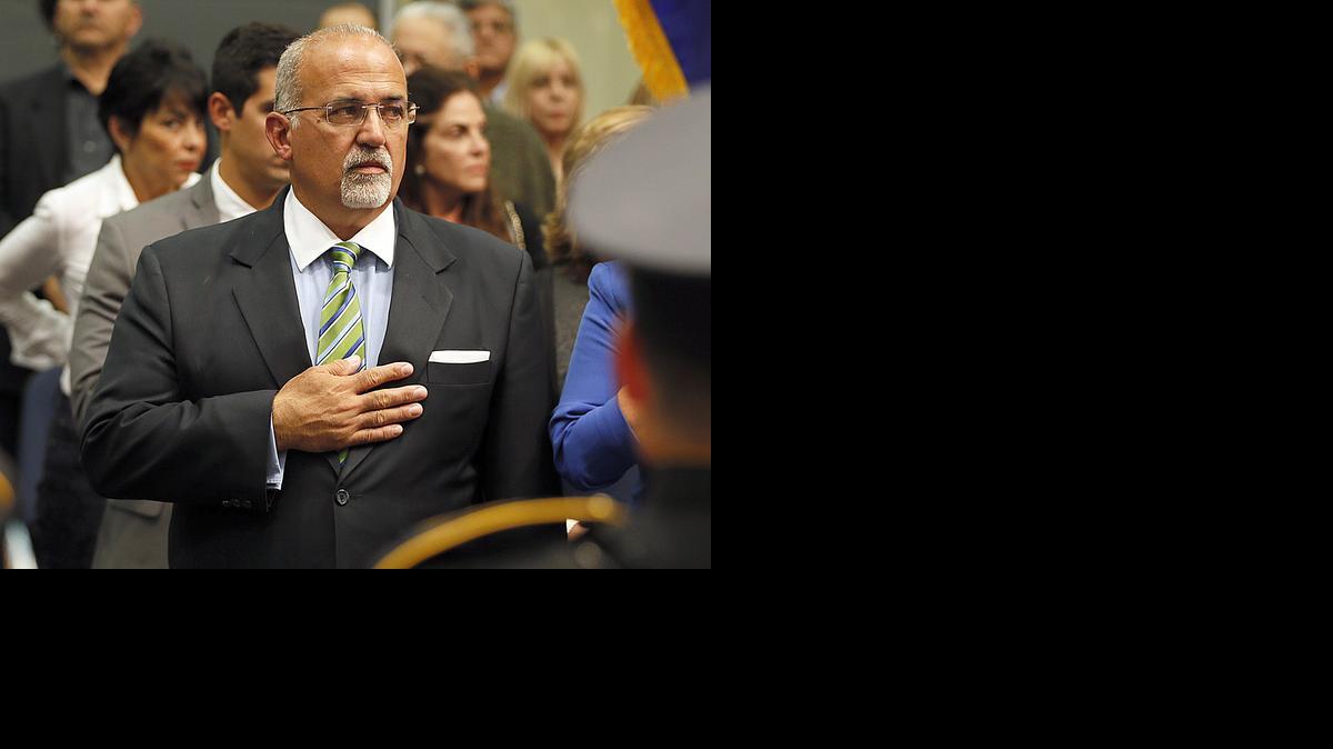 
Doral Councilman Pete Cabrera requested a special meeting to fire the city’s longtime city clerk, Barbara Herrera. He is shown above as he salutes the colors during his swearing ceremony at City Hall, on Nov. 5, 2014.
