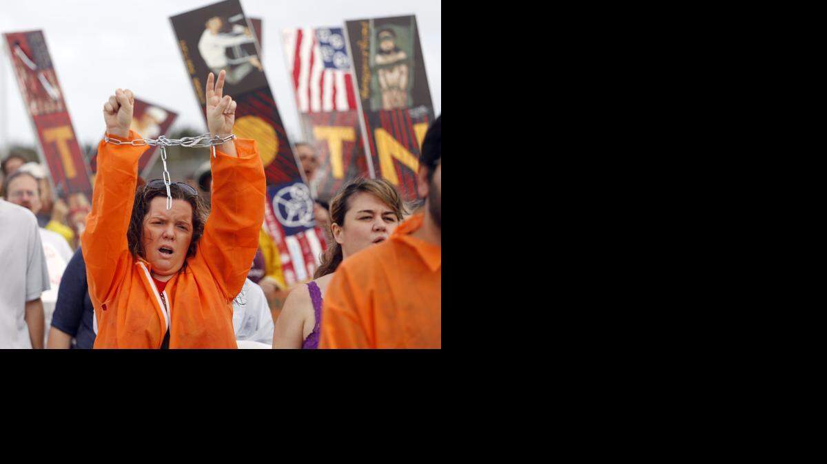 
On the left, protester Annette Quintero of Miami walks with her hands in chains. On the 13th anniversary of the Guantanamo Bay prison facilities, about 60 people walked to U.S. Southern Command demanding the prison’s closure.


