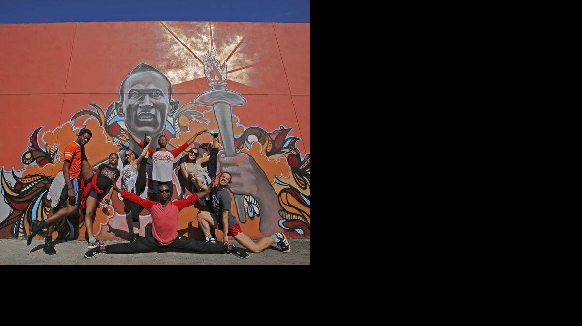 
Members of the Miami Contemporary Dance Company strike a pose in front of a mural paying tribute to four-time Olympic gold-medalist Jesse Owens before giving tango classes at the Overtown Youth Center. Owens, the celebrated track star of the 1936 Berlin Games, is being memorialized by the center with the mural, which was unveiled Monday. Story, Page 3. 
