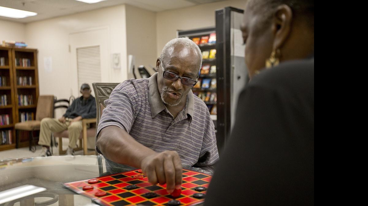 
Ralph Mitchell talks about his friend as he plays a game of checkers with Mildred Wilson at the Brownsville House on Thursday, June 11, 2015. Lazaro Valdivia, 53, died on Mother’s Day. The Brownsville Christian Housing Center community of friends-turned-family chipped in to give Valdivia a proper burial.
