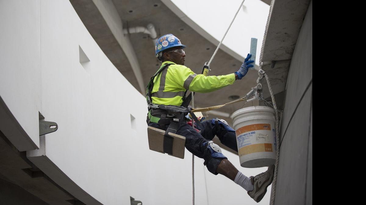
A construction worker sands the exterior of the in-progress planetarium at the Patricia and Phillip Frost Museum of Science on Biscayne Boulevard on Wednesday, July 29, 2015. The Miami Museum of Science will close on August 30, as construction continues on the new building, set to open in summer 2016.
