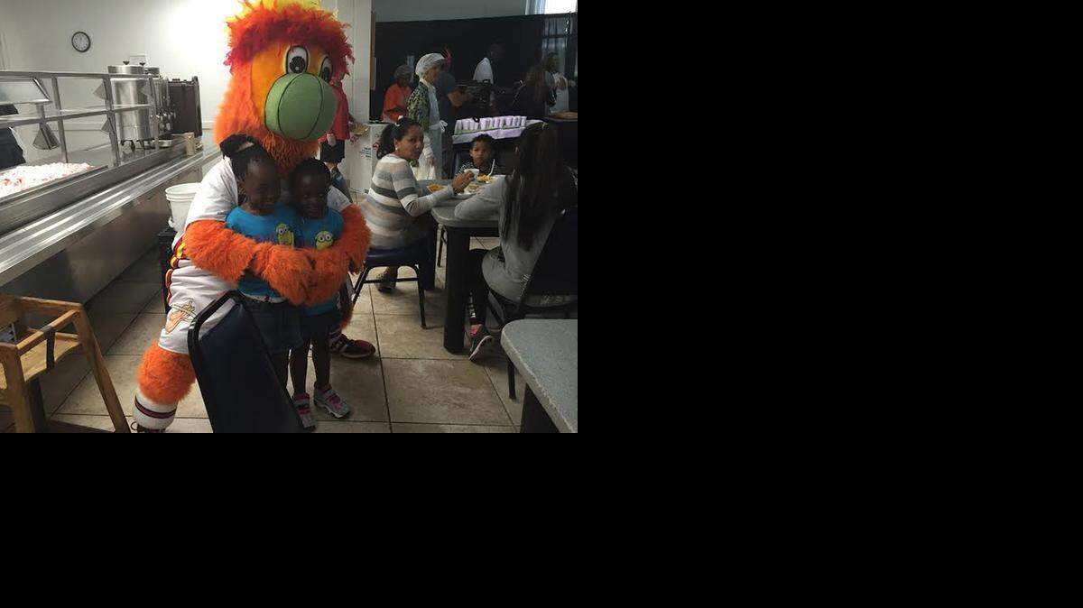 
Adriana Simmons, 7, left, and her sister Alexis, 5, get a hug from Miami Heat mascot Burnie on Monday at the Chapman Partnership.


