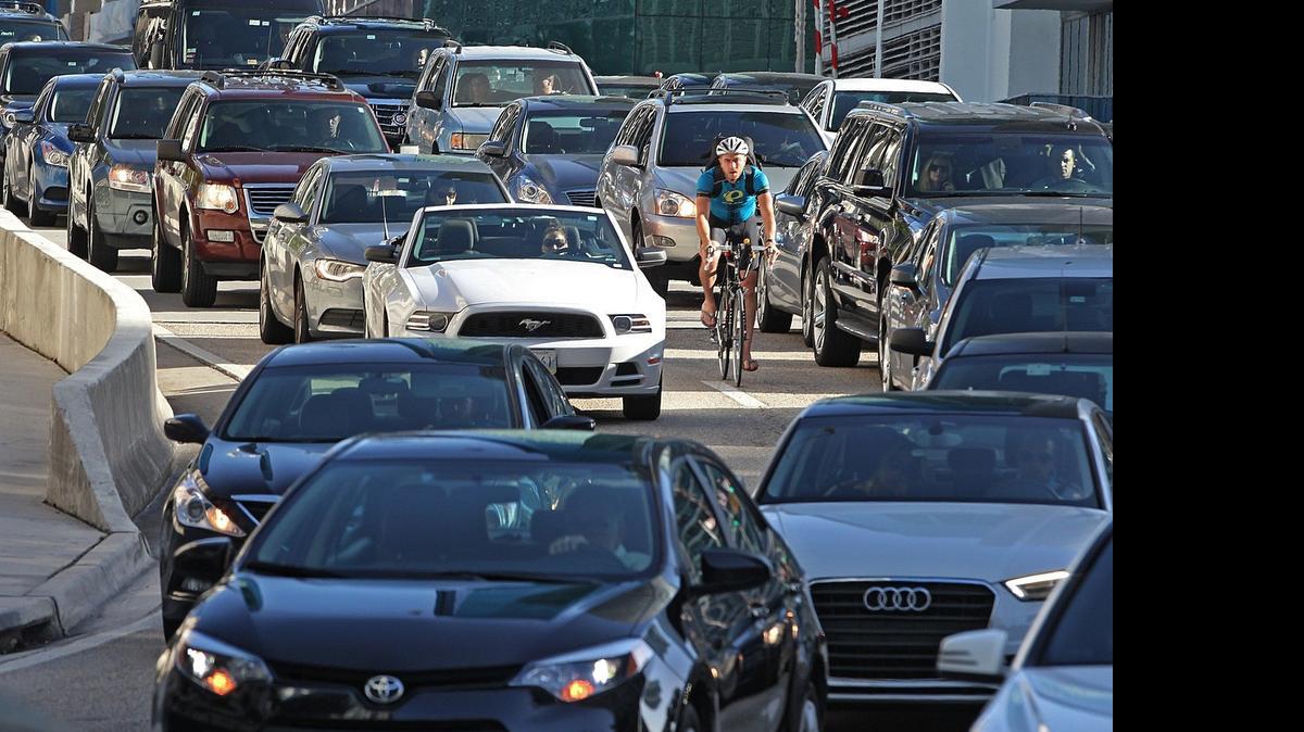 
Traffic comes to crawl as pedestrians, cyclists, and cars maneuver through morning traffic heading southbound over the Brickell Avenue Bridge 

