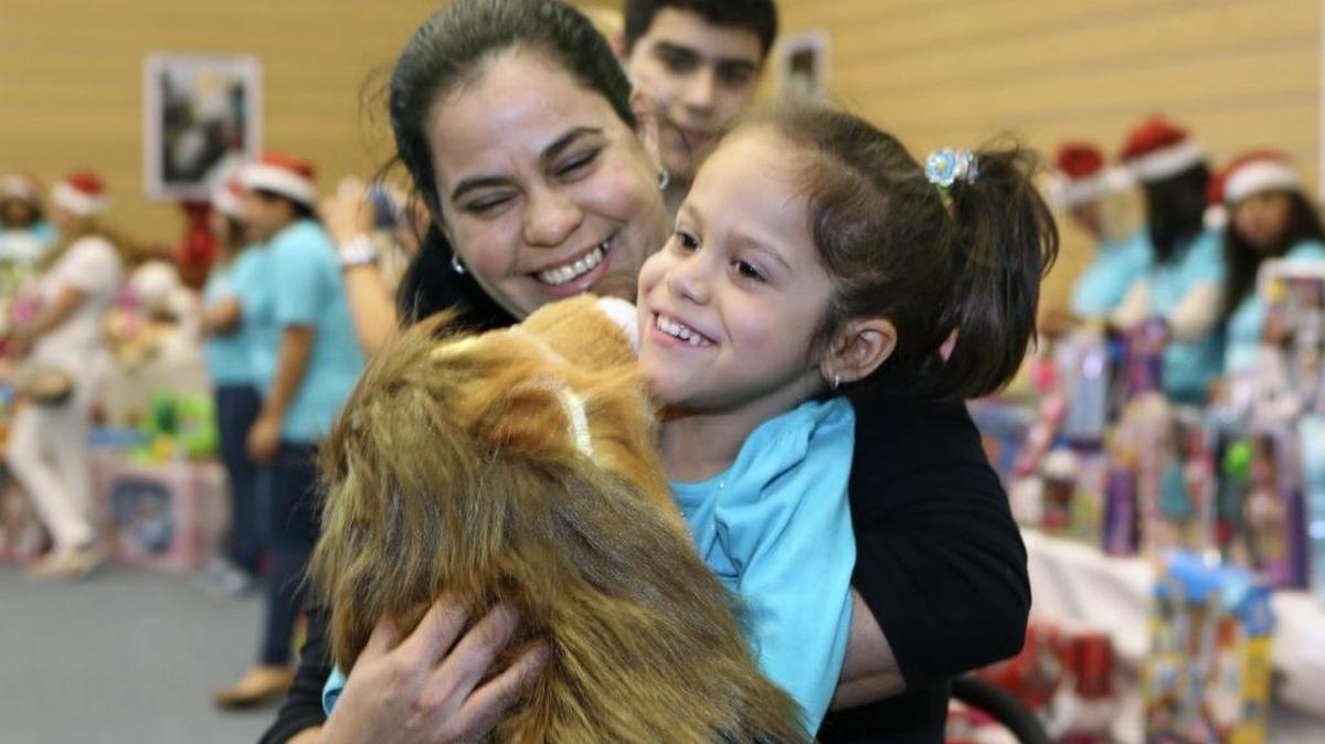 Lisa Marie Garcia, 4, with mom Lourdes Fernandez and brother Luis Salazar, embraces the new stuffed toy lion she received at The Little Lighthouse Foundation’s fourth annual Holiday Toy Drive on Saturday, Dec. 19, 2015 at Jungle Island in Miami. Lisa Marie has arthrogryposis multiplex congenita, a condition in which her joints are fixed in a position, affecting their function and range of motion.