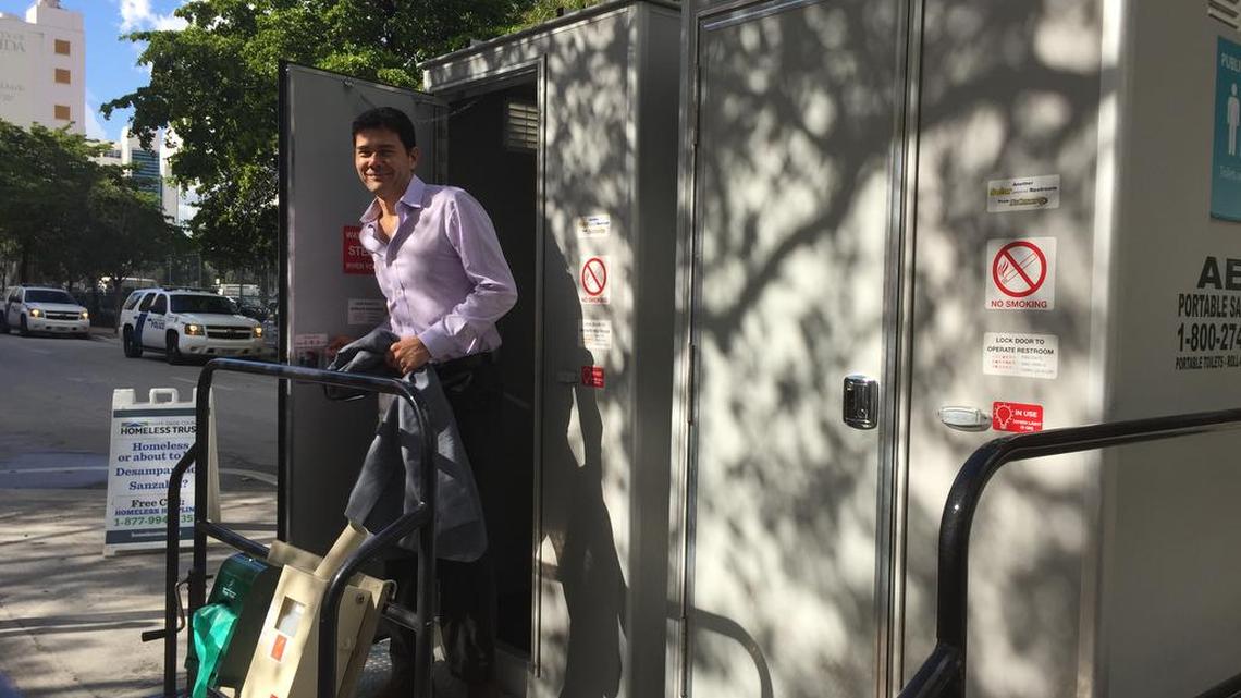 Miami Commissioner Ken Russell steps out of a Pit Stop toilet Friday.