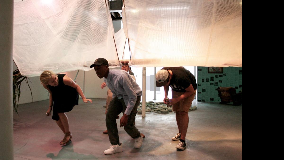 
Kelly Eriksen, Ezekiel Binns, center, Theo Rodino, right, and Matthew Alvarez, back, are walking underneath one of the art pieces they created in Locust Arts Builders, a three-week summer intensive program where students collaborate as both artists and curators to create an art exhibit from scratch. Their work is on display at Locust Projects, a non-profit gallery space in Miami’s Design District.
