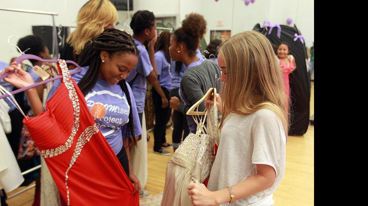 
Derika Marquess (left) looks a prom dress along with Syndney Sazant (right) who started the PROMises Project, a philanthropic endeavor to provide young women from Booker T. Washington High in Overtown with dresses for prom night. Thursday, April 30, 2015.
