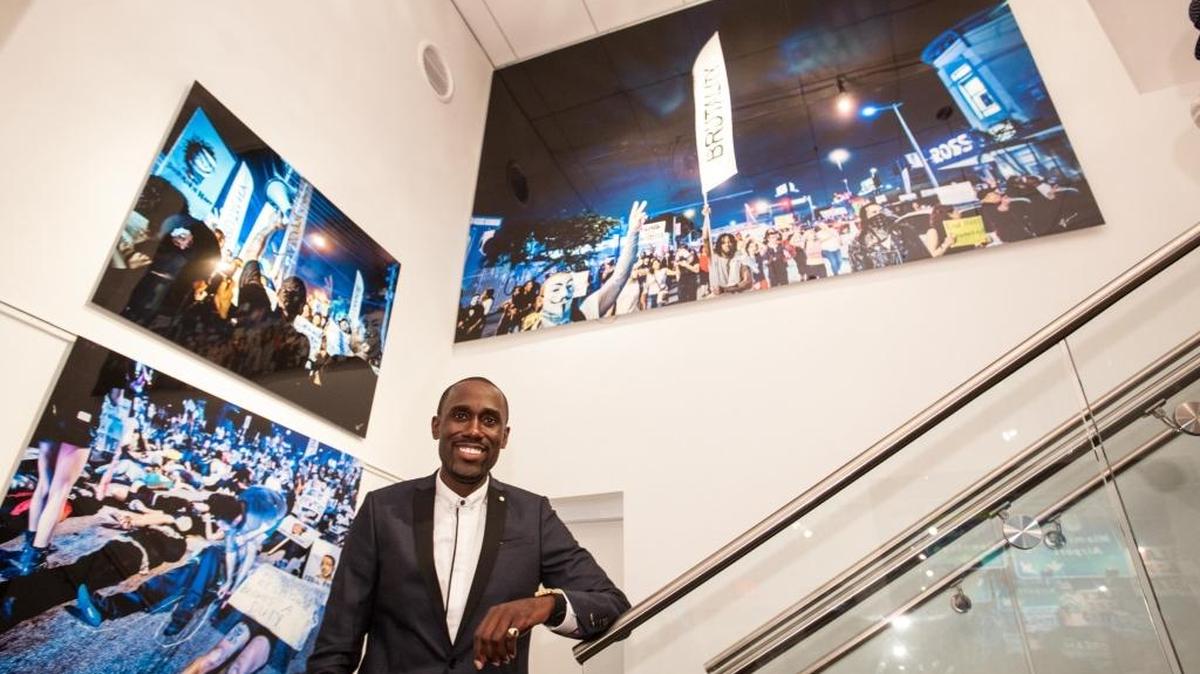 
Cendino Temé poses Aug. 27 with photographs he took of Black Lives Matter protests. The photos are on exhibition at the Ward Rooming House Gallery, 249 NW Ninth St., Miami.
