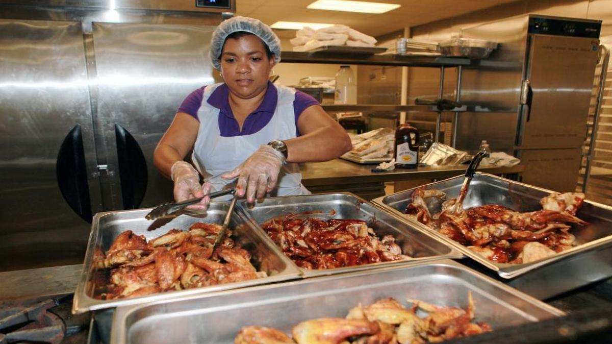 A volunteer helps prepare food at Camillus House in 2016.