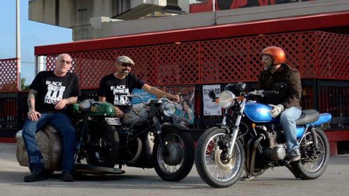 
Nick Bowe, 43, Alex MacKenzie, 47, and Robert Schafer, 44, pose with their motorcycles in front of Will Call Miami in Downtown where vintage motorcycle enthusiasts will gather for the annual Black Sunday swap meet. 
